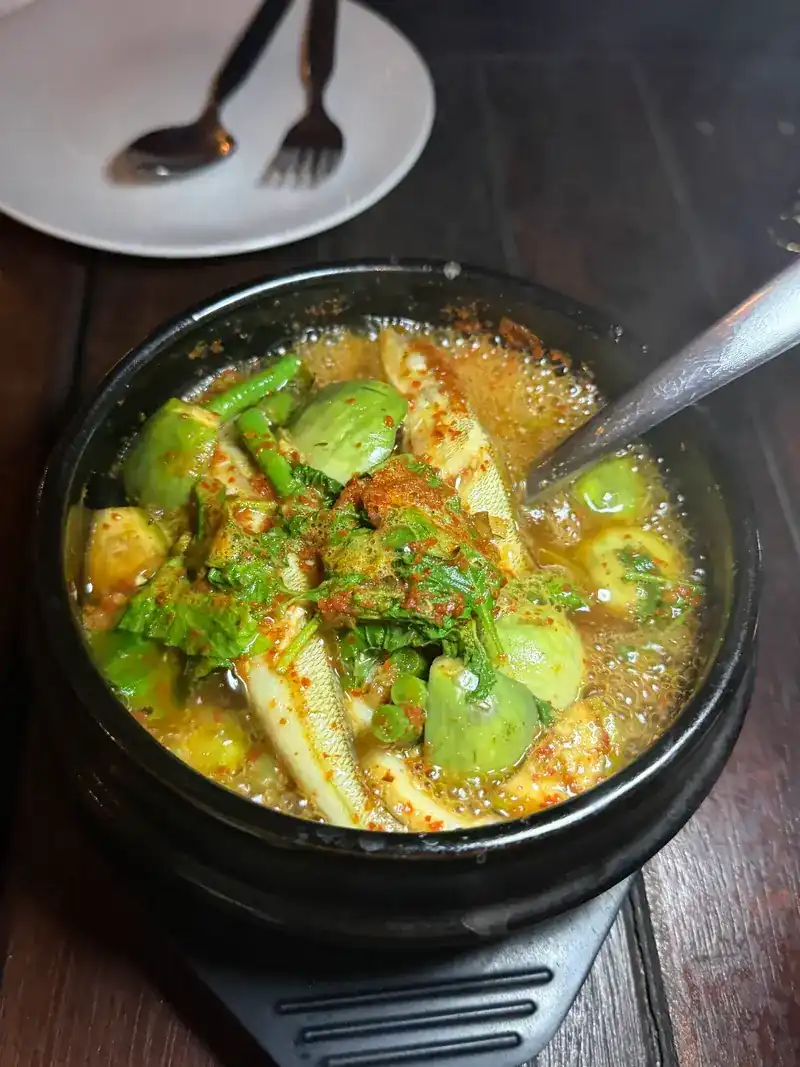 A vegetable curry in a black pot