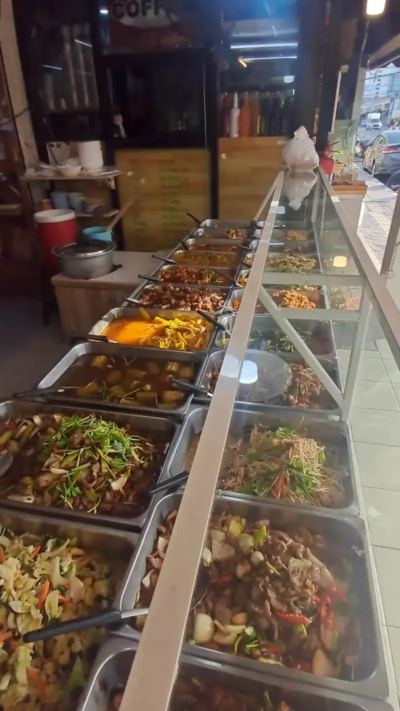 The long glass counter lined with trays of food