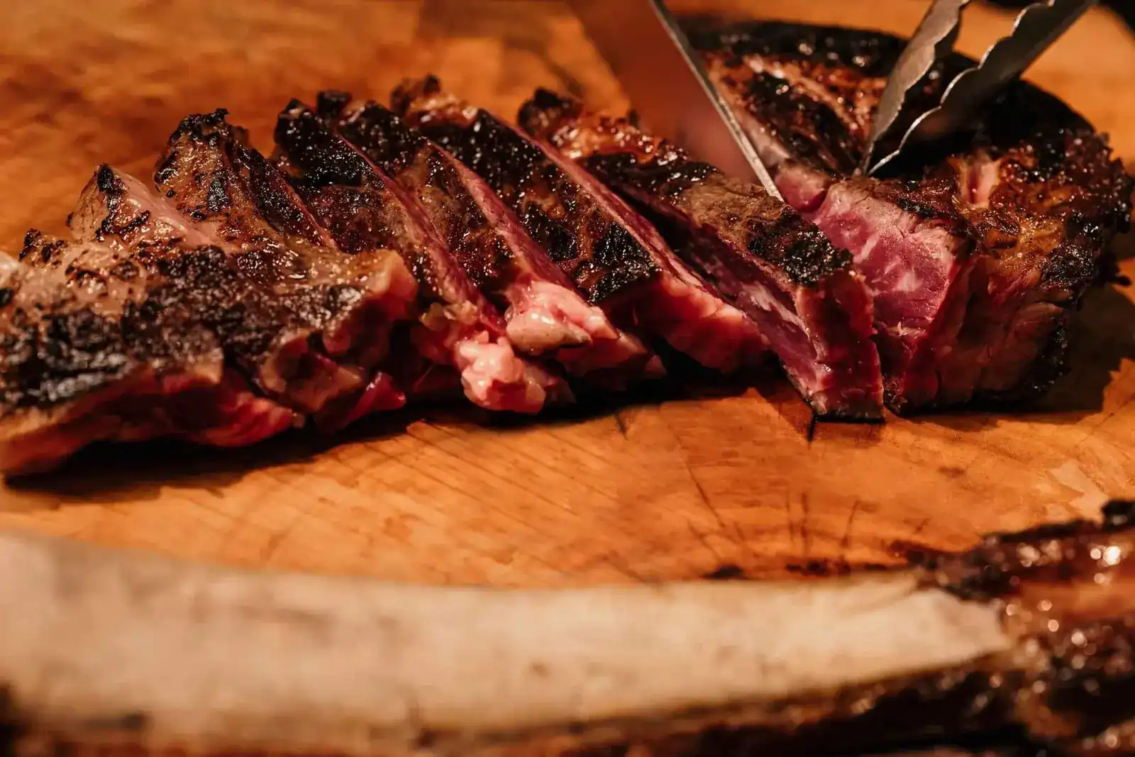 Sliced beef on a wooden board, carved from the bone