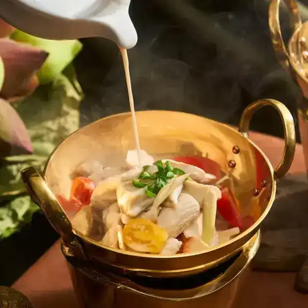 Coconut soup poured into a brass pot