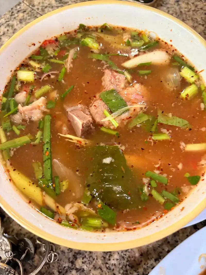 A bowl of spicy, sour Isan soup with pork