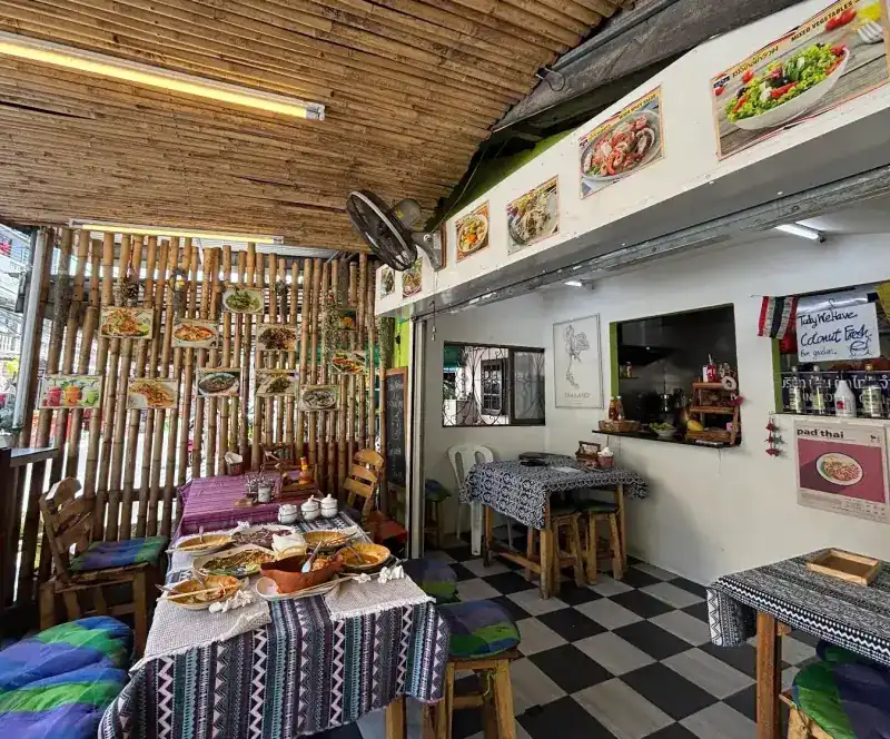Inside: bamboo walls and ceiling, a black and white checkered floor and woven cloths on the tables