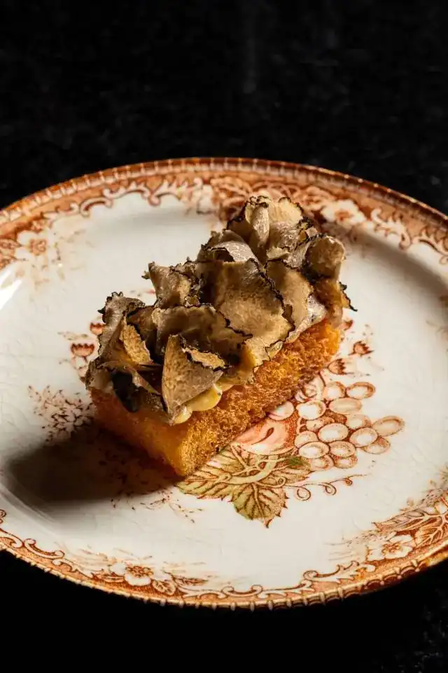 French toast under shaved black truffle on a vintage plate