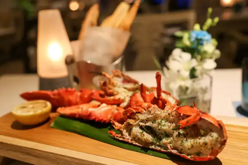 Grilled lobster halves with lemon on a banana leaf