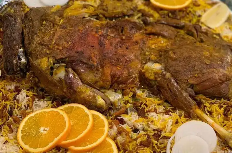 Slow-roasted lamb on spiced rice with orange slices