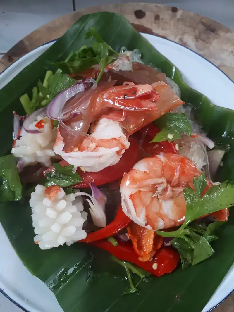 Seafood salad with prawns and squid on a banana leaf