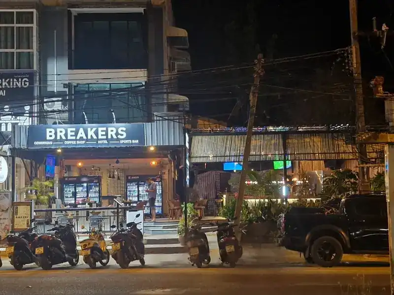 Breakers seen from Wiset Road at night, with scooters parked along the front