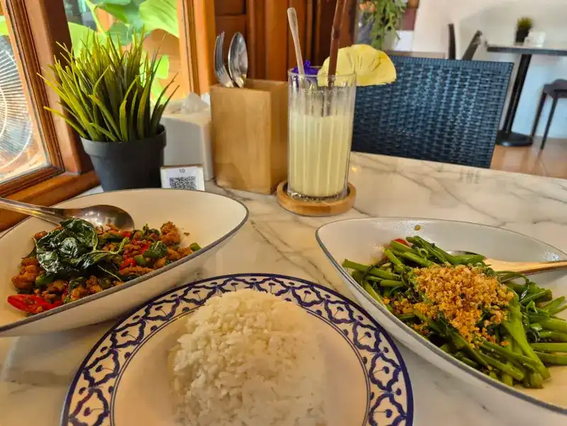 A spicy stir-fry topped with crisp basil, stir-fried greens, steamed rice and a smoothie