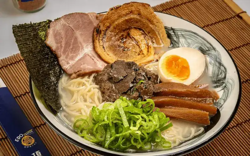 Ramen topped with chashu, sliced pork, nori, half an egg and spring onion