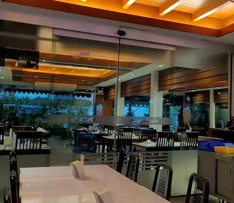 The air-conditioned dining room, with timber ceilings, glass walls and white tables