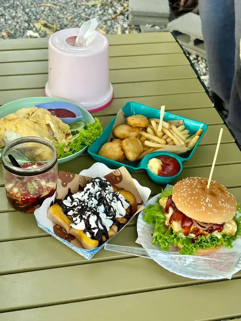 A burger, fries and nuggets on a green camp table