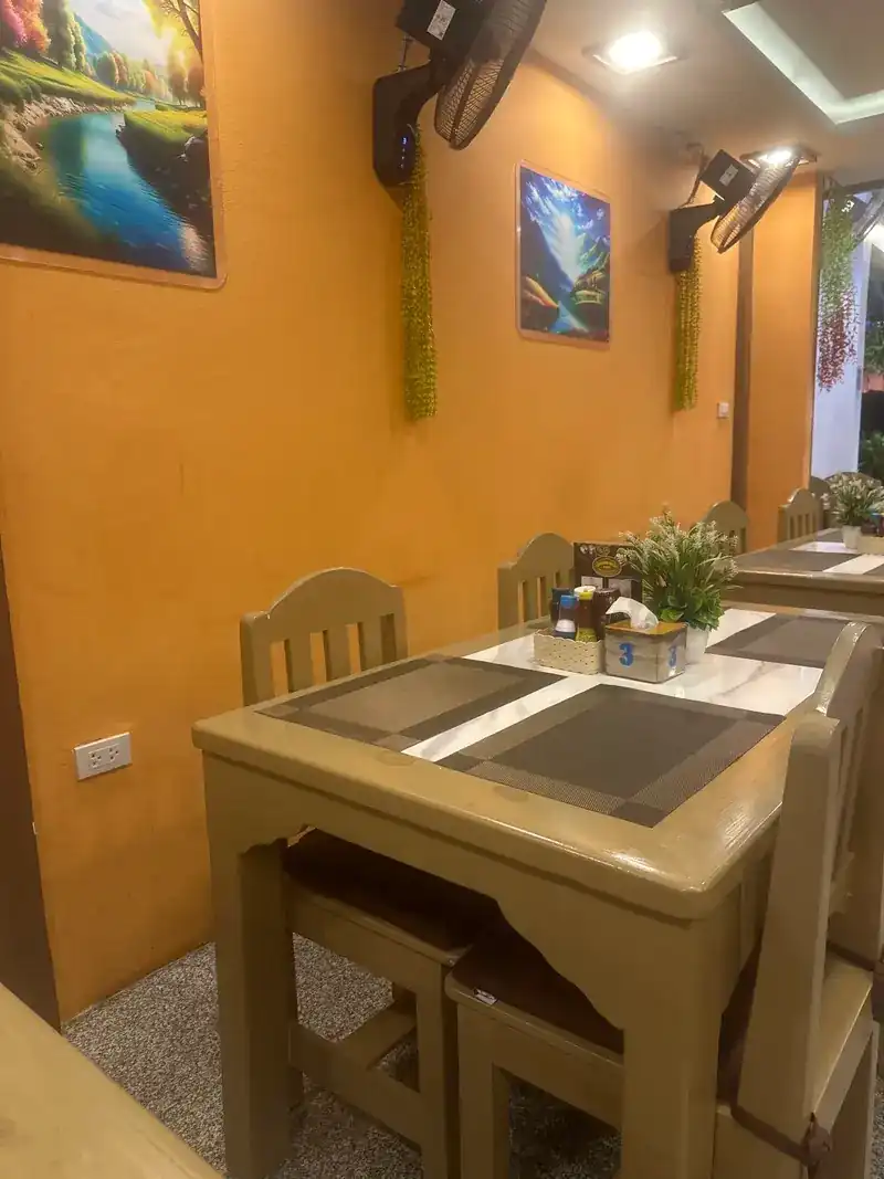 The dining room: orange walls, paintings and wooden tables