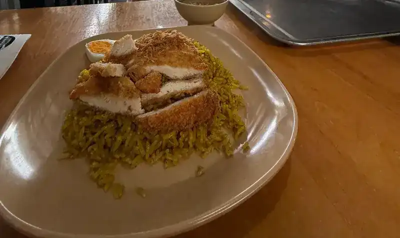 Yellow rice topped with crisp fried chicken and a boiled egg