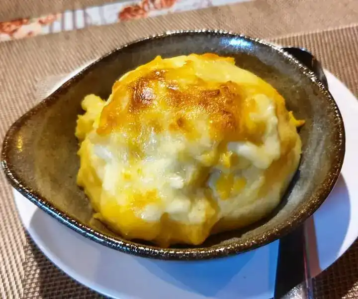 Mashed potato baked under golden cheese