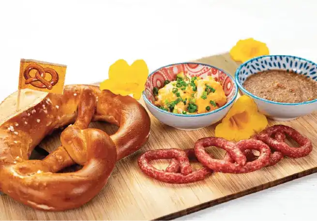Brotzeit board: a fresh pretzel, obatzda cheese dip, mini salamis and sweet mustard