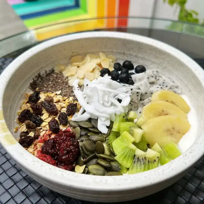 Breakfast bowl topped with fruit, seeds and oats