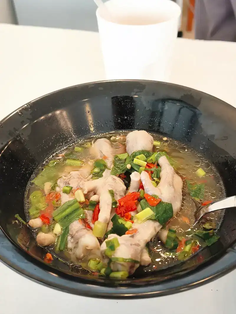 Chicken feet in a spicy soup with chilli and spring onion
