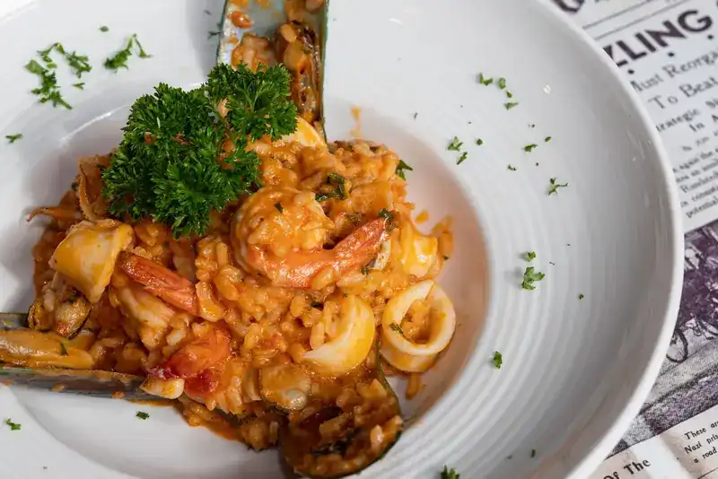 Seafood risotto with prawns, squid rings and mussels, topped with parsley