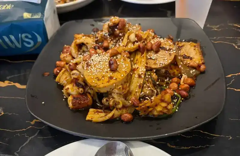 Dry mala with peanuts and sesame on a black plate