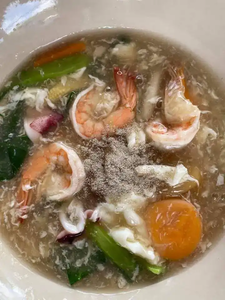 Prawns and squid with greens and egg in a thick gravy, sprinkled with pepper — กุ้งและปลาหมึกกับผักและไข่ ในน้ำราดข้น โรยพริกไทย