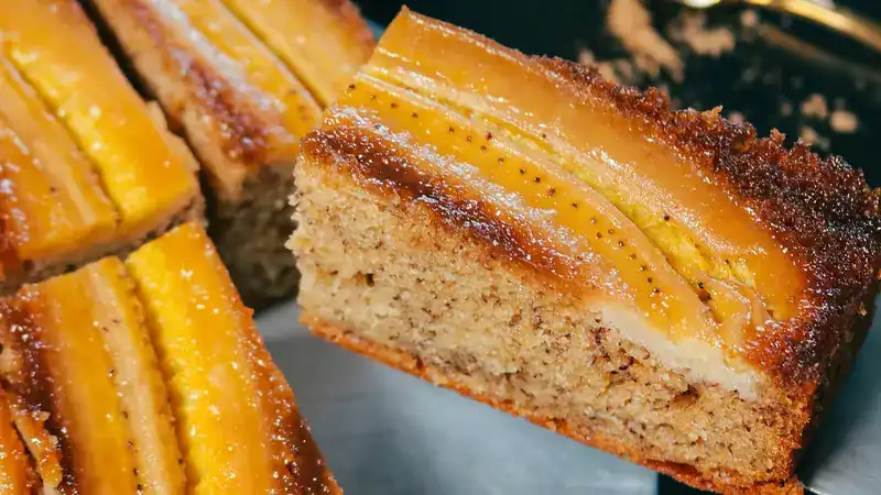 A thick slice of banana cake with caramelised banana strips across the top