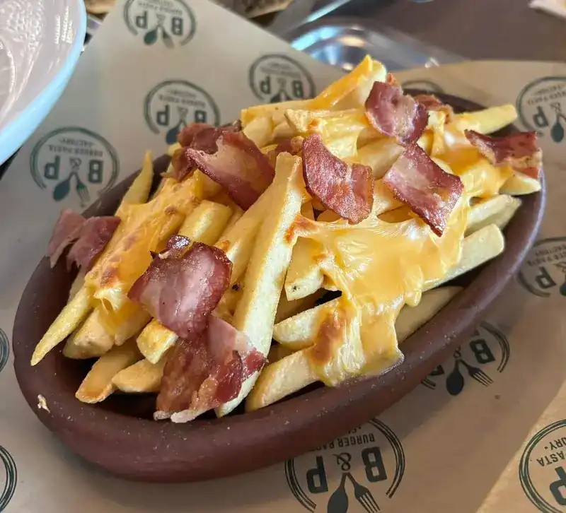 French fries with melted cheddar and bacon on B&P tray paper