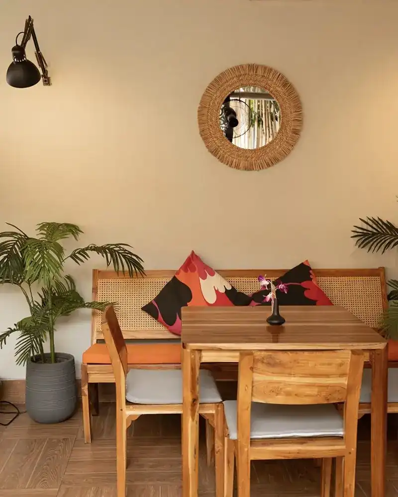 A rattan sofa corner with patterned cushions and a palm