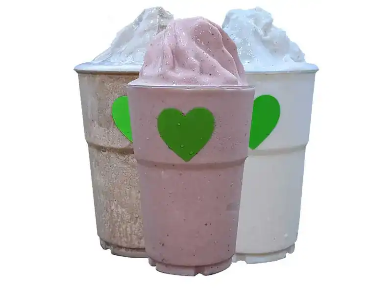 Three protein shakes in cups with a green heart on each