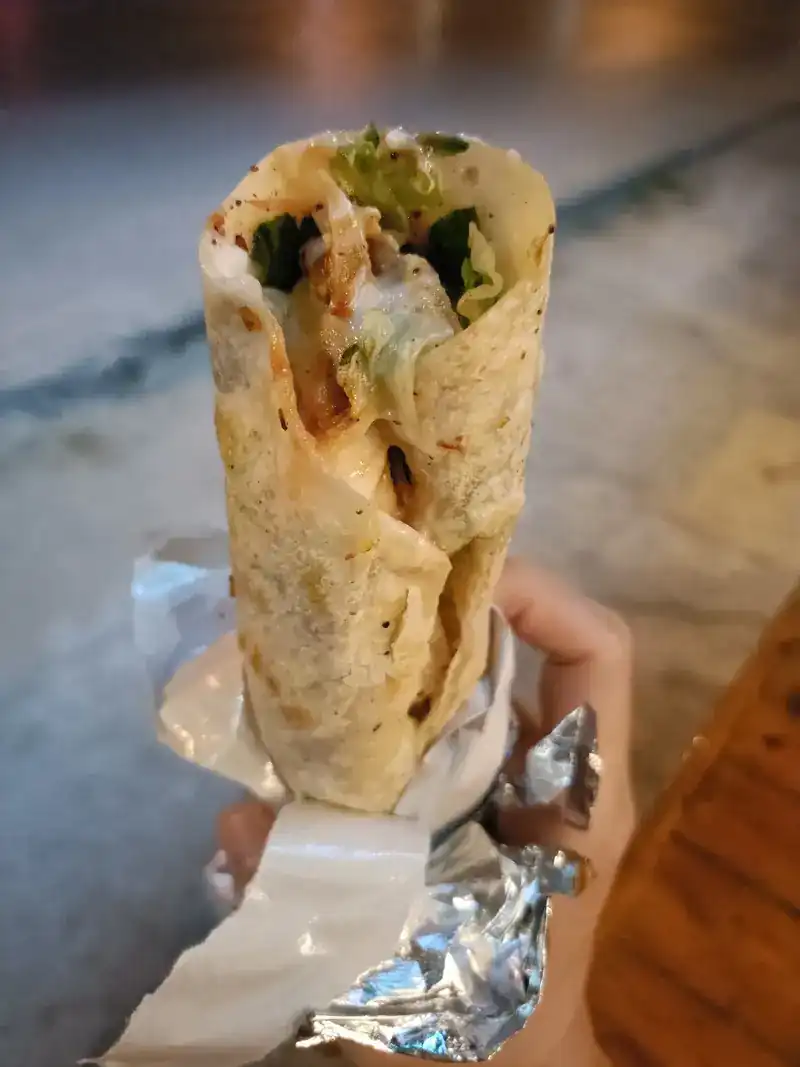A kebab wrap in foil, held in the hand