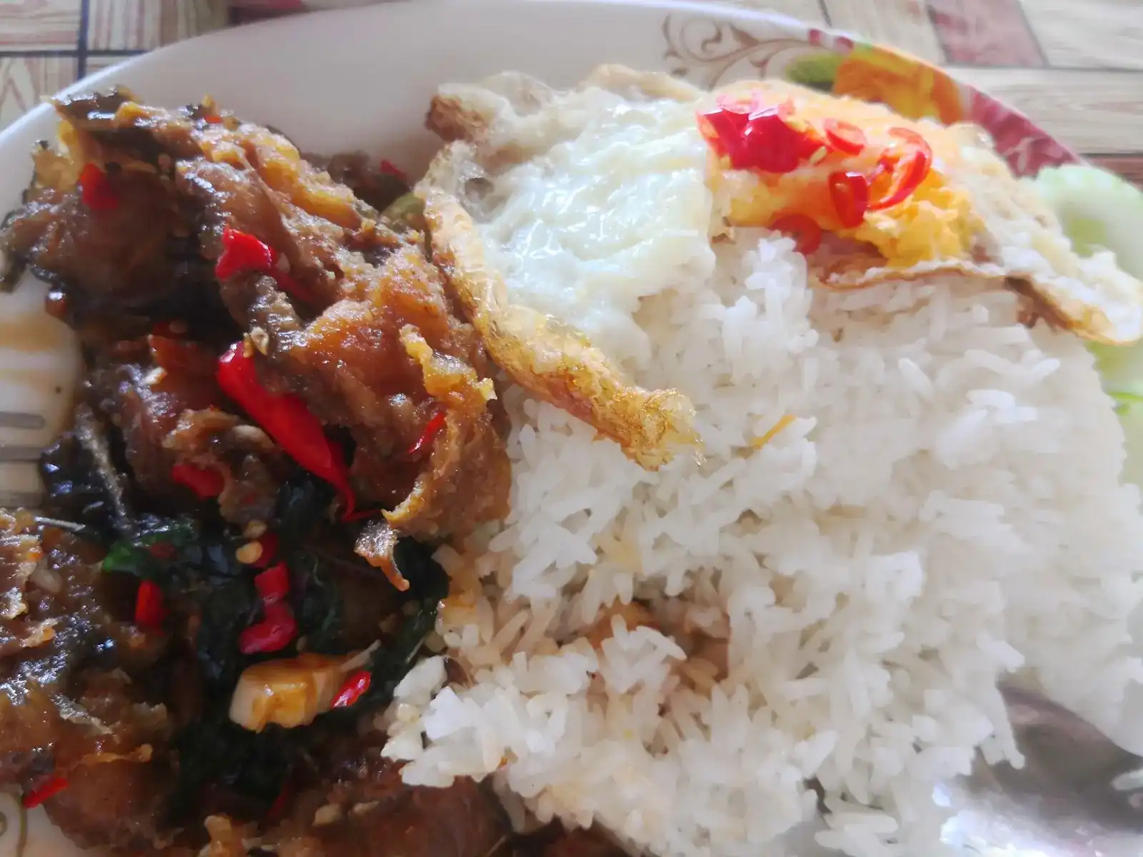 A basil and chilli stir-fry on rice with a fried egg