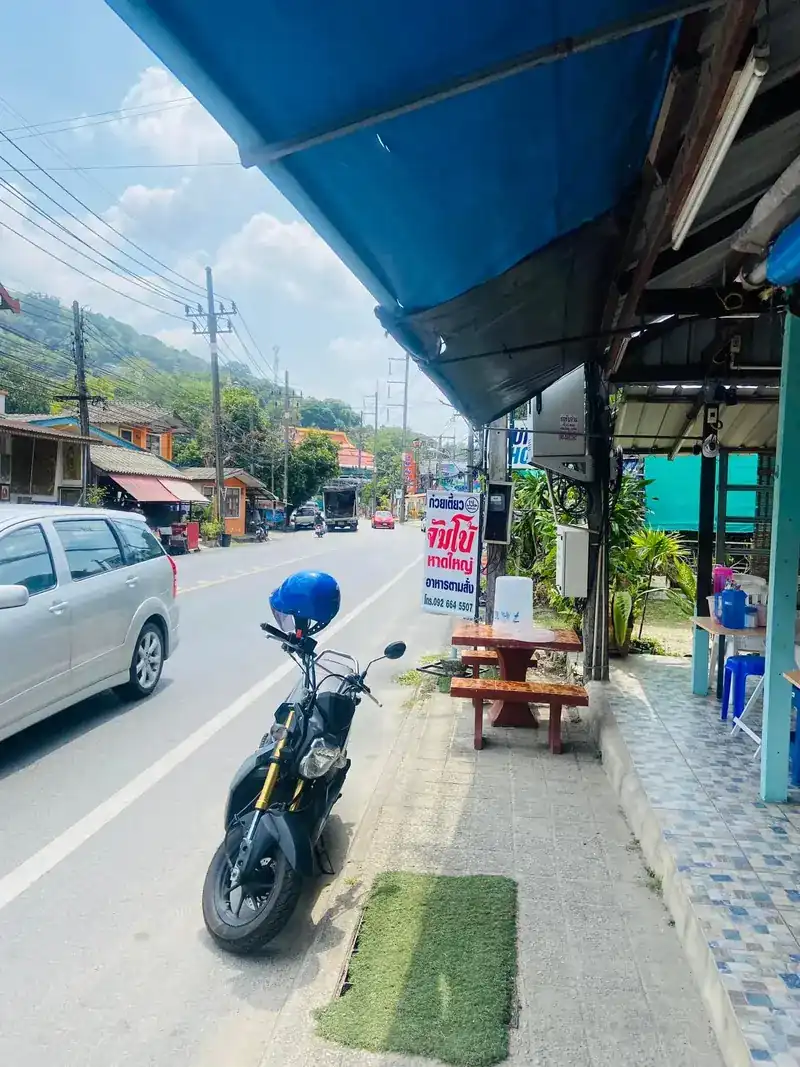 The shop front by the road: blue awning, a roadside table and the red Jumbo sign