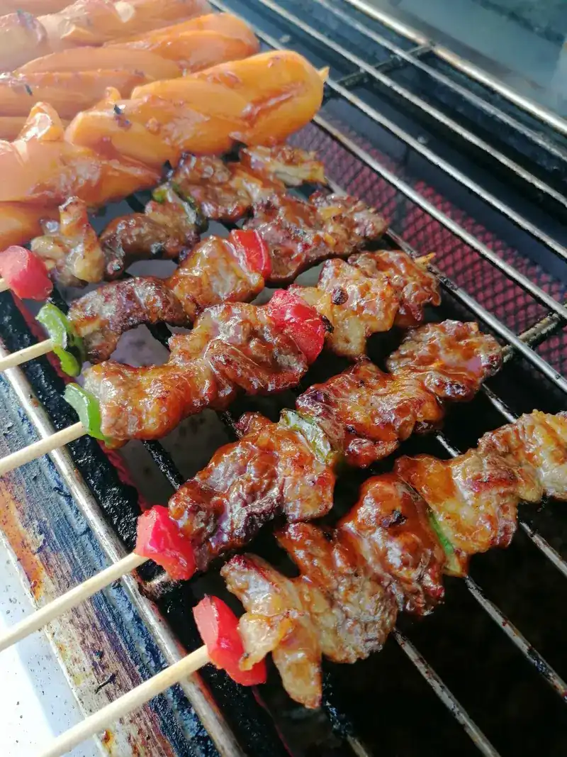 Chicken skewers with red pepper browning on the grill