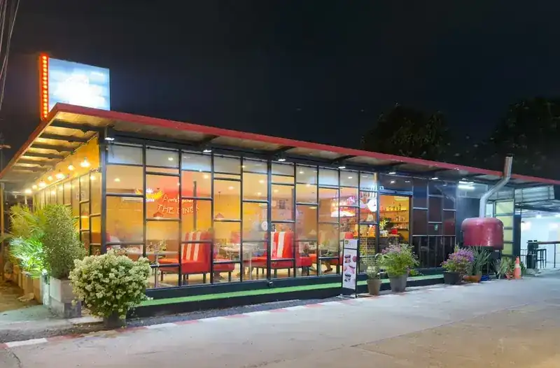 The diner at night, lit from inside, its red booths glowing behind the glass