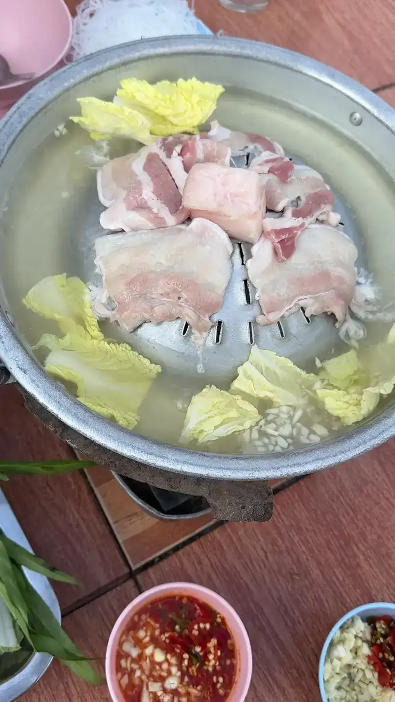 Raw pork belly on the pan with cabbage, dipping sauces beside it
