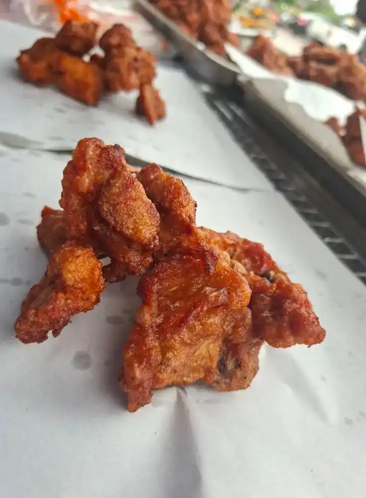 Crisp pieces of fried chicken laid out on white paper