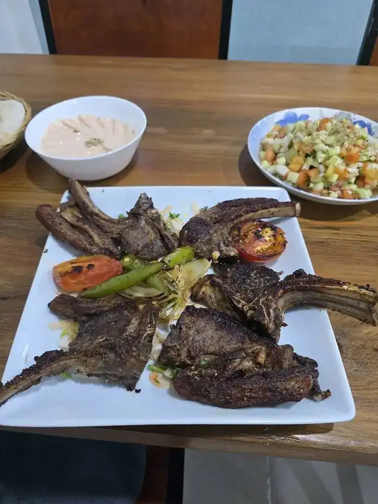 Grilled lamb chops with charred tomato and peppers, salad on the side