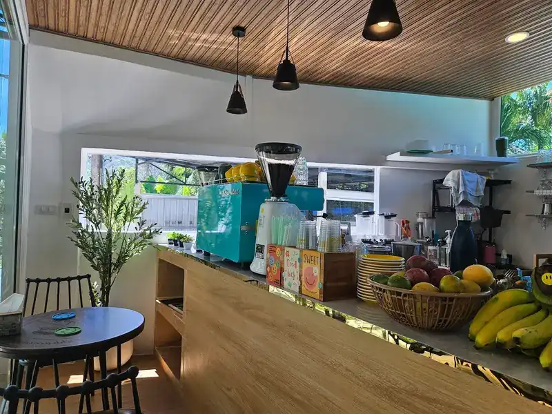 The counter with a teal coffee machine and baskets of fruit