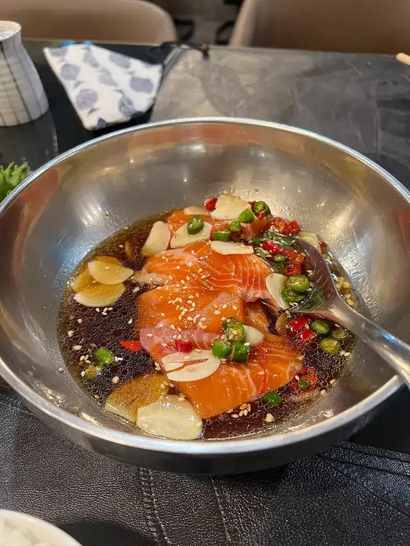 Salmon in soy marinade with garlic and chilli in a steel bowl