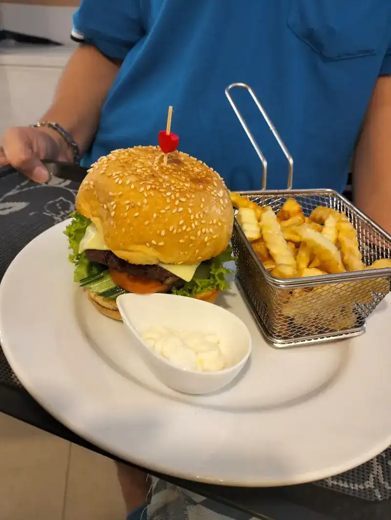 A burger with fries in a wire basket and a dip / เบอร์เกอร์กับเฟรนช์ฟรายส์ในตะกร้าและซอสจิ้ม