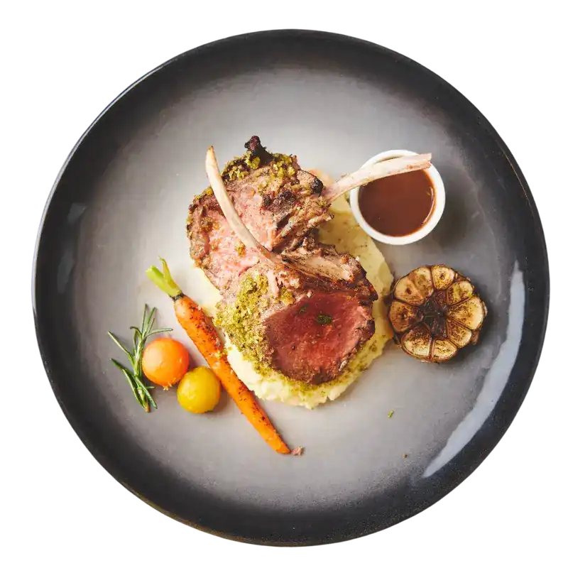 Grilled lamb cutlets on mashed potato with roast garlic