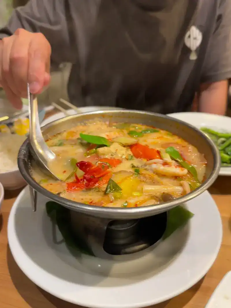 Tom yum in a hot pot over a burner