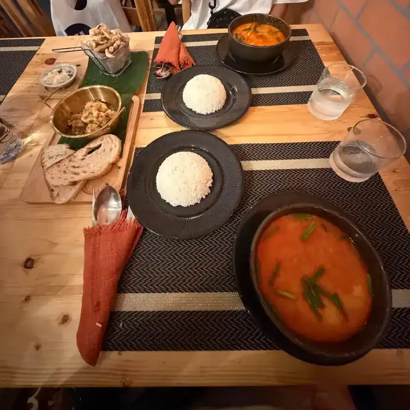 Curry, rice and bread on a wooden table