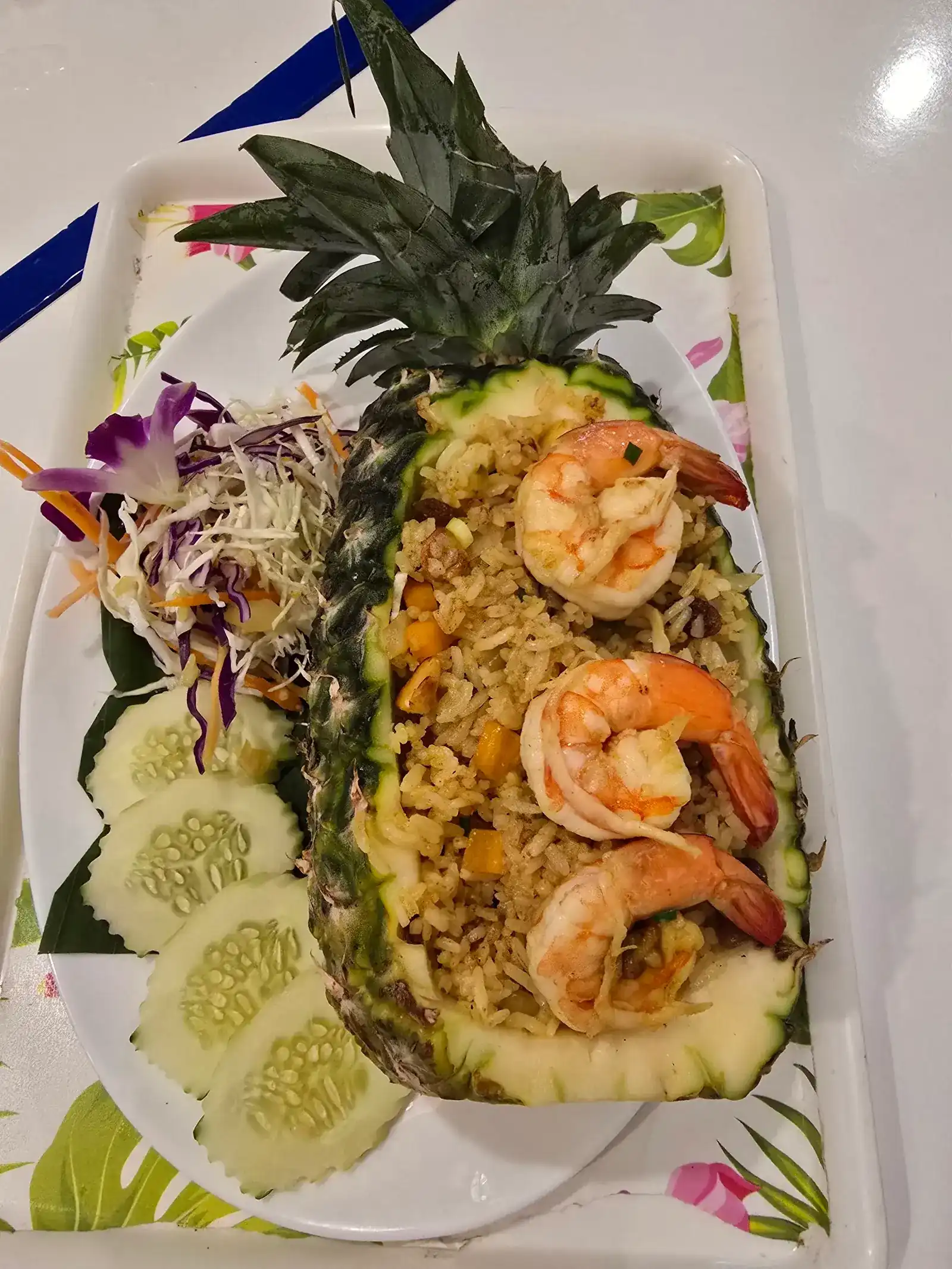 Pineapple fried rice with prawns, served in half a pineapple with an orchid / ข้าวผัดสับปะรดกุ้ง เสิร์ฟในสับปะรดครึ่งลูกพร้อมดอกกล้วยไม้