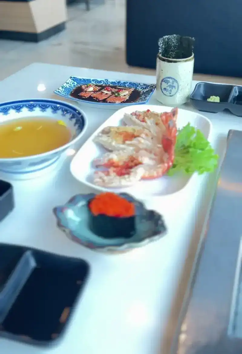 Salmon in sauce, grilled prawns, a bowl of soup and a fish-roe gunkan