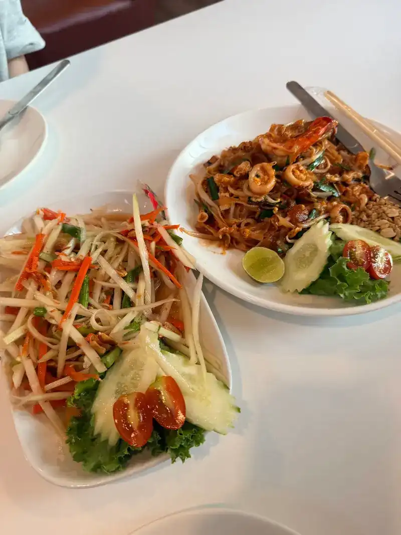 Papaya salad and a plate of stir-fried noodles with prawns