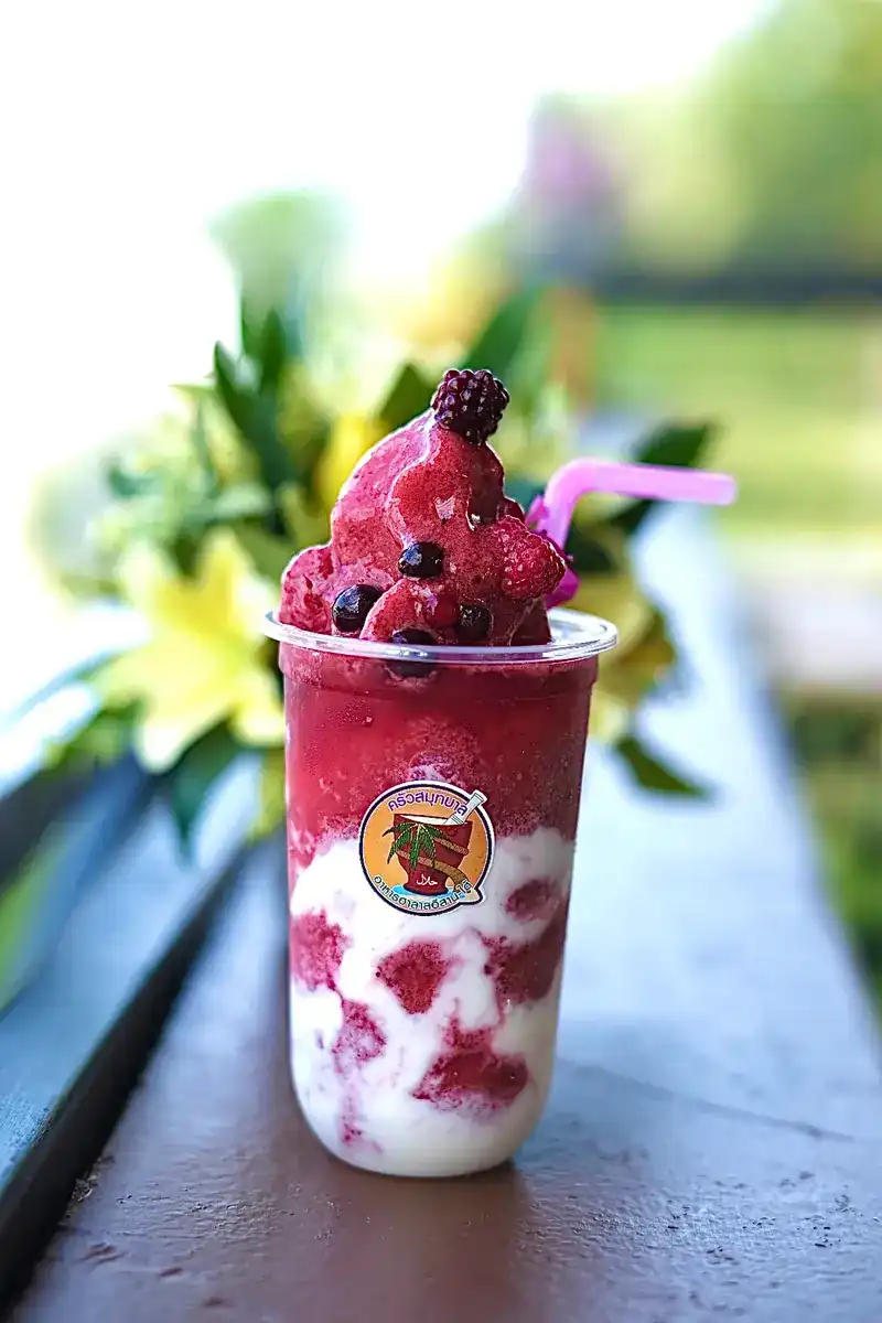 A berry smoothie topped with frozen berries