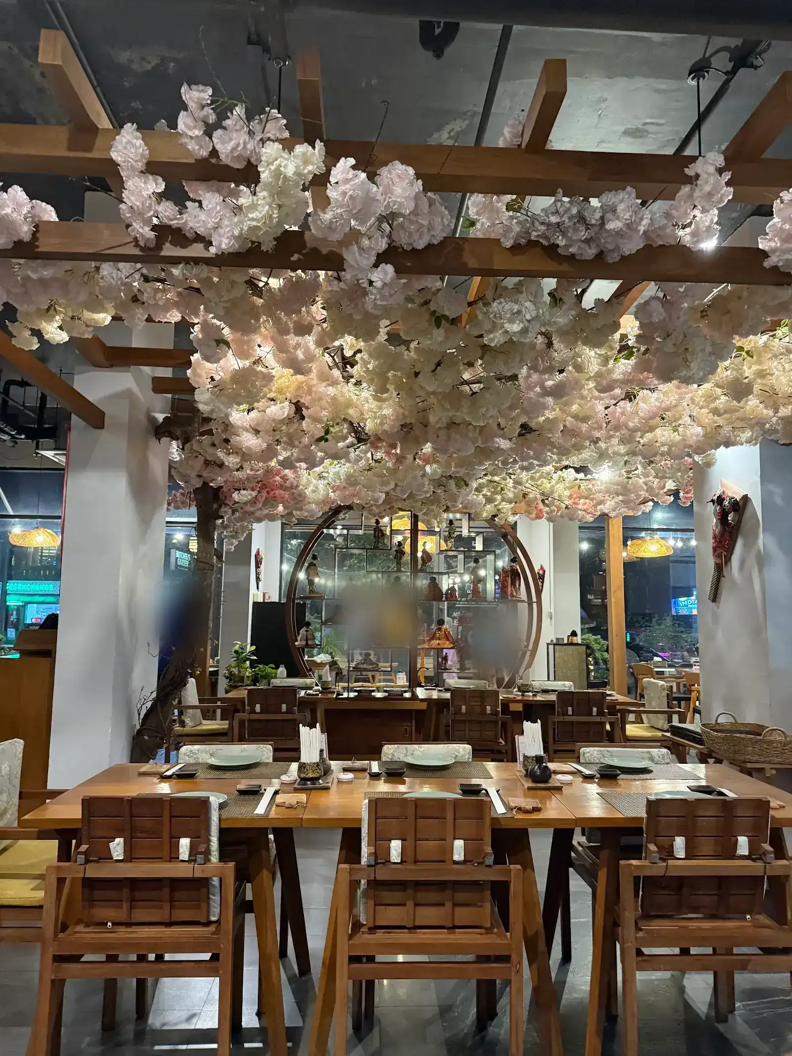 Dining room with wooden tables under a ceiling of pink and white blossoms / ห้องอาหารโต๊ะไม้ ใต้เพดานดอกซากุระสีชมพูและขาว
