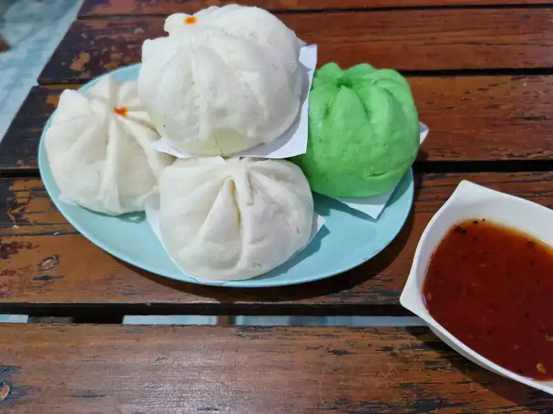 White and green steamed buns with a chilli dip