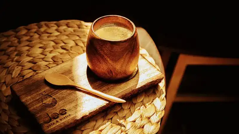 Hot coffee in a wooden cup on a dee board