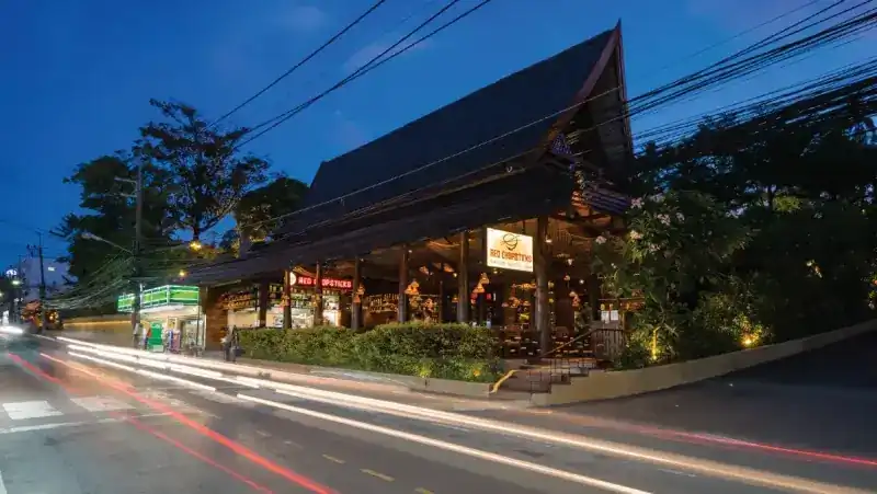 The restaurant's wooden house with its tall roof on Karon Road at dusk